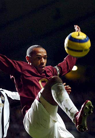 Henry salta a por el balón en un partido de la Liga inglesa.