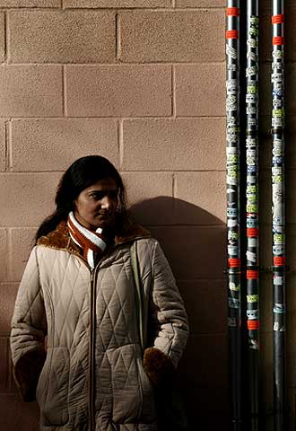 Los inmigrantes suman el 16,3% de la población de Orriols. Una de ellas espera junto a montones de ofertas de servicios.