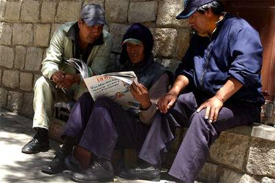 Tres ciudadanos de La Paz leen en un diario las informaciones sobre la victoria electoral de Evo Morales.