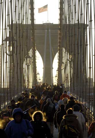 Cientos de neoyorquinos cruzan a pie el puente de Brooklyn para ir a Manhattan.
