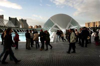 Visitantes pasean por la Ciudad de las Ciencias, con L'Hemisfèric al fondo.