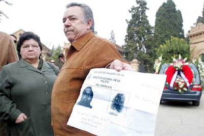 Conocidos de la víctima muestran una foto, suministrada por la policía, del hombre fugado.