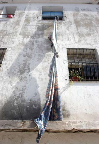 Fachada del edificio donde murieron el padre y su hija con unas sábanas anudadas a una ventana por las que descendieron algunos vecinos.