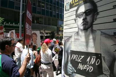 Partidarios de Bachelet pasan junto a un cartel con una imagen de Pinochet, en Santiago.