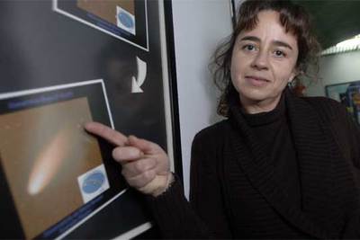 Luisa María Lara, junto a imágenes del cometa Tempel 1, en el que impactó un proyectil de  Deep Impact.  
