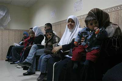 Padres y madres esperan con sus hijos en la sala de pediatría del hospital Al Jedma al Amma, de Gaza.