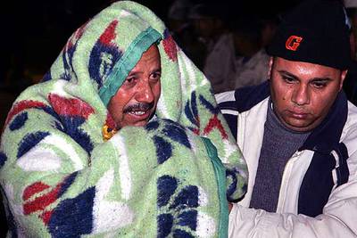 Un tripulante del  Elanora  ayuda a un superviviente del naufragio a desembarcar en el puerto egipcio de Hurghada.