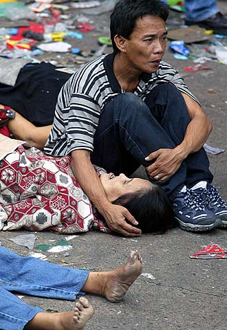 Un hombre acaricia el cadáver de su mujer a las afueras del estadio.