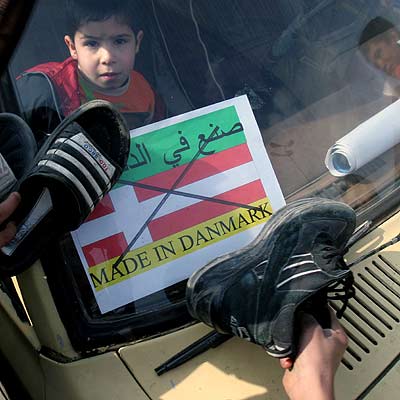 Varios iraquíes golpean con sus zapatos una bandera danesa el pasado miércoles en Bagdad para protestar contra las viñetas publicadas en septiembre de 2005 por el diario  Jyllands Posten .