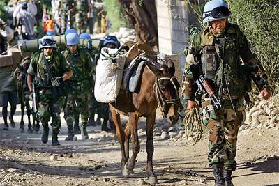  Cascos azules  uruguayos ayudan a transportar urnas hacia un colegio electoral de Puerto Príncipe.