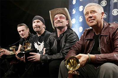 Larry Mullen Jr., The Edge, Bono y Adam Clayton, miembros de U2 (de izquierda a derecha), con sus cinco  grammies.  Abajo, el  rapero  Kanye West, con sus tres premios.