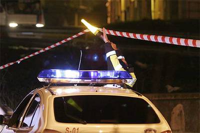 Un  ertzaina  abre paso a un coche policial en la zona de la explosión.