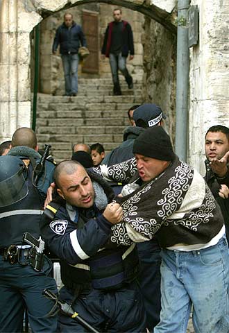 Un policía israelí forcejea con un palestino para impedirle la entrada a la mezquita de Al Aqsa, en el centro histórico de Jerusalén.
