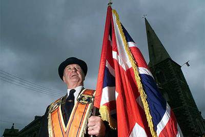 Un manifestante de la Orden de Orange protesta la prohibición oficial de desfilar por el barrio católico de Portadown para evitar enfrentamientos.