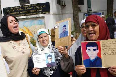 Mujeres argelinas muestran fotos de sus hijos desaparecidos en Argel en 2005.