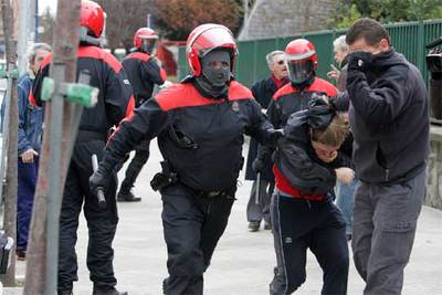 Agentes de la Ertzaintza detienen a uno de los participantes en la protesta de ayer en Vitoria.