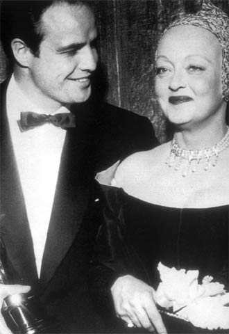 Marlon Brando, con el galardón al mejor actor por  La ley del silencio,  en 1955, junto a Bette Davis, quien le hizo entrega del premio.