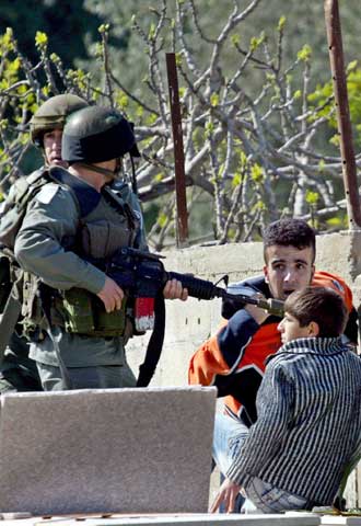 Dos soldados israelíes detienen a dos niños palestinos durante una operación militar en Jenín (Cisjordania), ayer.