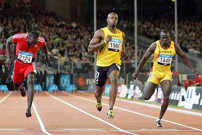 Asafa Powell, en medio, se impone a Marc Burns, de Trinidad y Tobago, y a Aziz Zakari, de Ghana.
