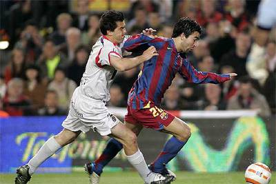 Deco conduce el balón acosado por Contra.