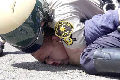 Un manifestante es inmovilizado por un policía durante una protesta contra la ley de inmigración en San Diego.
