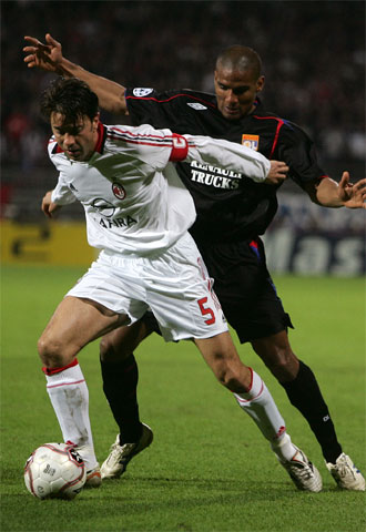 Costacurta protege el balón acosado por Malouda.