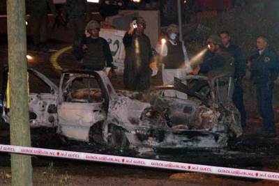 Soldados israelíes examinan el coche en el que se produjo la explosión, ante la colonia de Kedumim.