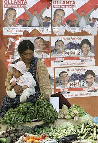 Una campesina en un mercado de Arequipa ante carteles electorales.