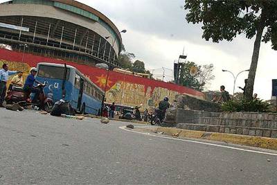 El asesino huye en moto (en el centro, junto a un muro); en la imagen pequeña, el fotógrafo venezolano muerto, Jorge Aguirre.