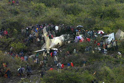 Equipos de rescate y lugareños rodean bajo la lluvia los restos del avión estrellado en Marsabit (Kenia).