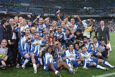 Los jugadores del Espanyol posan eufóricos sobre el césped con el trofeo ganado.
