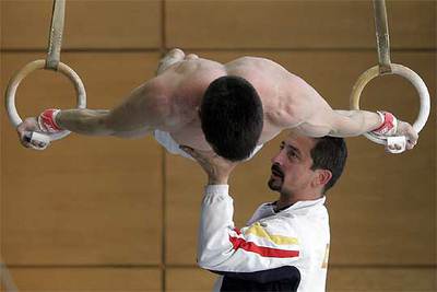 Un gimnasta se prepara para el Campeonato de Europa de mayo, con la ayuda de su entrenador, en el Centro de Alto Rendimiento de Madrid.