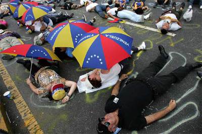 Decenas de opositores simulan una escena del crimen durante la protesta de ayer en Caracas.