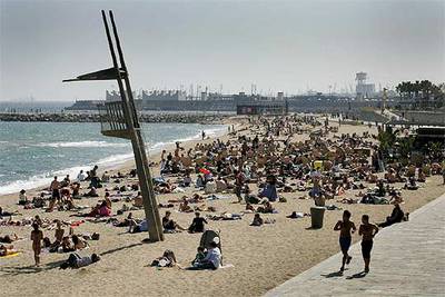 Baños de sol en la playa del Bogatell