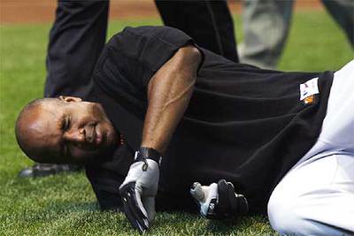 Bonds, noqueado en el suelo, tras recibir un pelotazo en la cara, ayer, en Milwaukee.