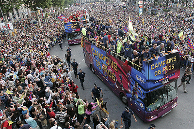 Los autobuses de la  rua  enfilan el paseo de Gràcia desde la plaza de Catalunya ante miles de aficionados.