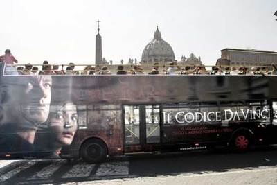 El anuncio de  El código Da Vinci  en un autobús  enmarca,  el viernes, la cúpula de San Pedro, en el Vaticano.