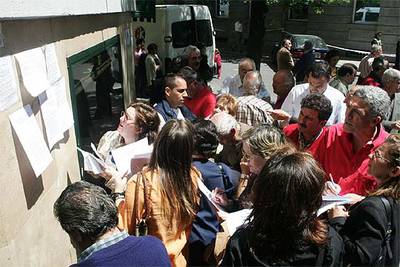 Afectados por la estafa buscan información en el exterior de la sede de Fórum Filatélico en Madrid.