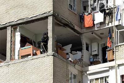 Un bombero de Fuenlabrada derriba unos ladrillos de una de las fachadas dañada por la explosión de gas.