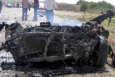 Agentes estadounidenses y afganos inspeccionan la zona donde un suicida estrelló su coche ayer en Herat (Afganistán).