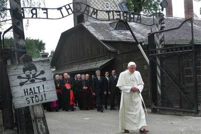 El Papa atraviesa la puerta del campo de concentración de Auschwitz, donde se lee en el letrero de la izquierda 