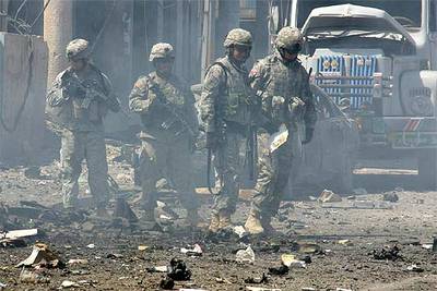 Soldados de EE UU inspeccionan el lugar de un atentado que causó 20 heridos ayer en Mosul, en el norte de Irak.