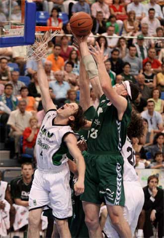 Santiago coge un rebote ante Huertas, a la izquierda, y Flis.