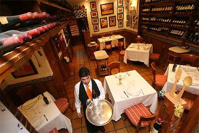 Comedor del restaurante Jota Cinco, en Madrid. Abajo, degustación de tres bacalaos (pil-pil, vizcaína y club Ranero).