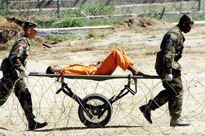 Policías militares llevan a un preso de Guantánamo a una sala de interrogatorios, en febrero de 2002.