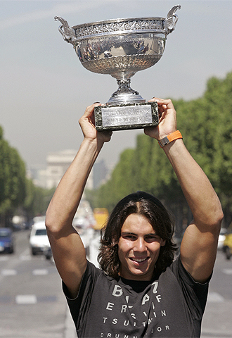 Nadal, con el Arco del Triunfo al fondo, alza el trofeo de Roland Garros.
