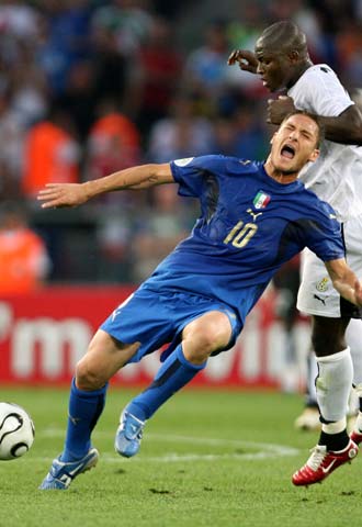 Totti, en el momento de caer al suelo tras una entrada de Muntari.