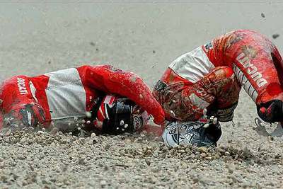 Capirossi (izquierda) y su compañero de equipo Gibernau, en el suelo.