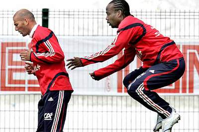 Chimbonda salta detrás de Zidane en un ejercicio del entrenamiento de la selección francesa.