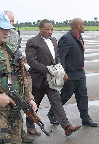 Taylor, rodeado de soldados de la ONU, camina hacia el avión que lo trasladó a La Haya.